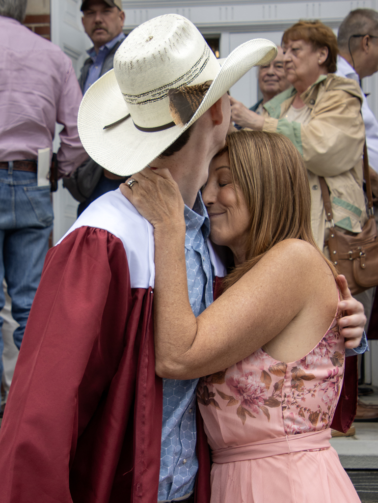 mother hugs son wearing a cowboy hat