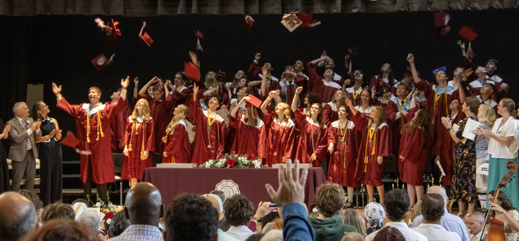 graduates toss their hats in the air