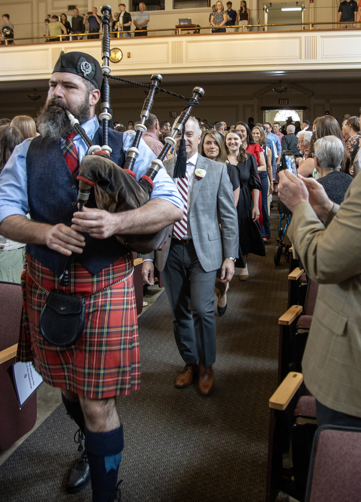 bagpiper leads the teachers and principals in