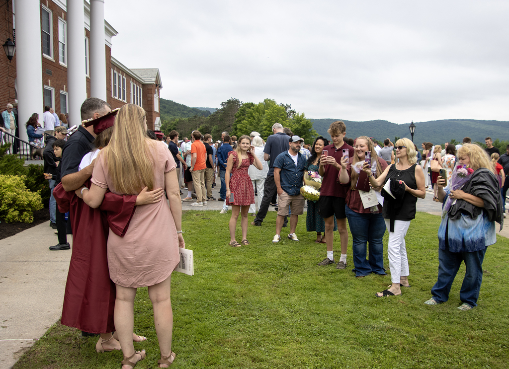 graduates pose for pictures in front of school