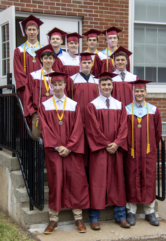 11 graduates pose on steps