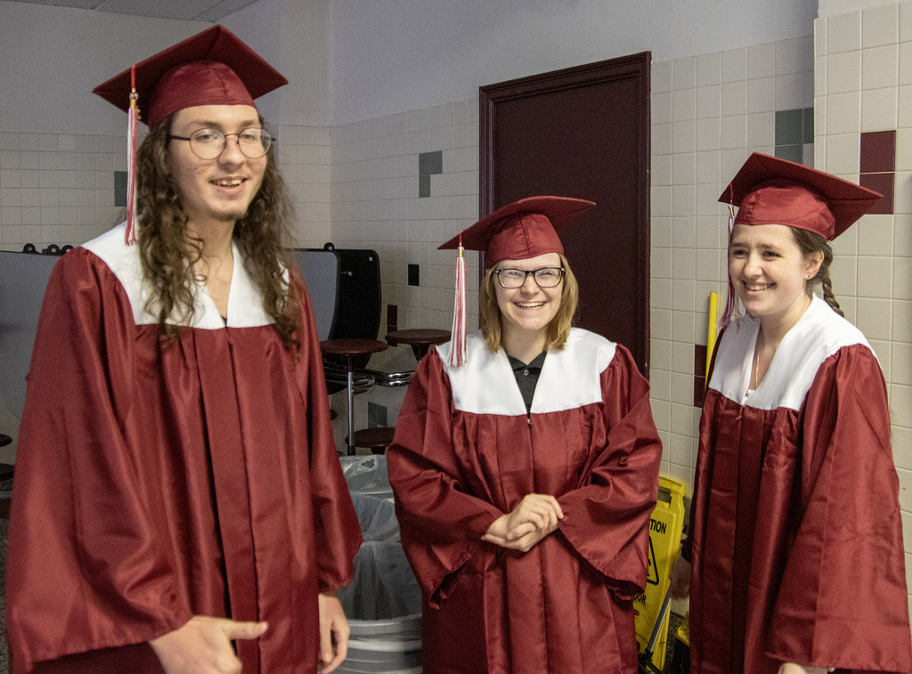 3 graduates smile