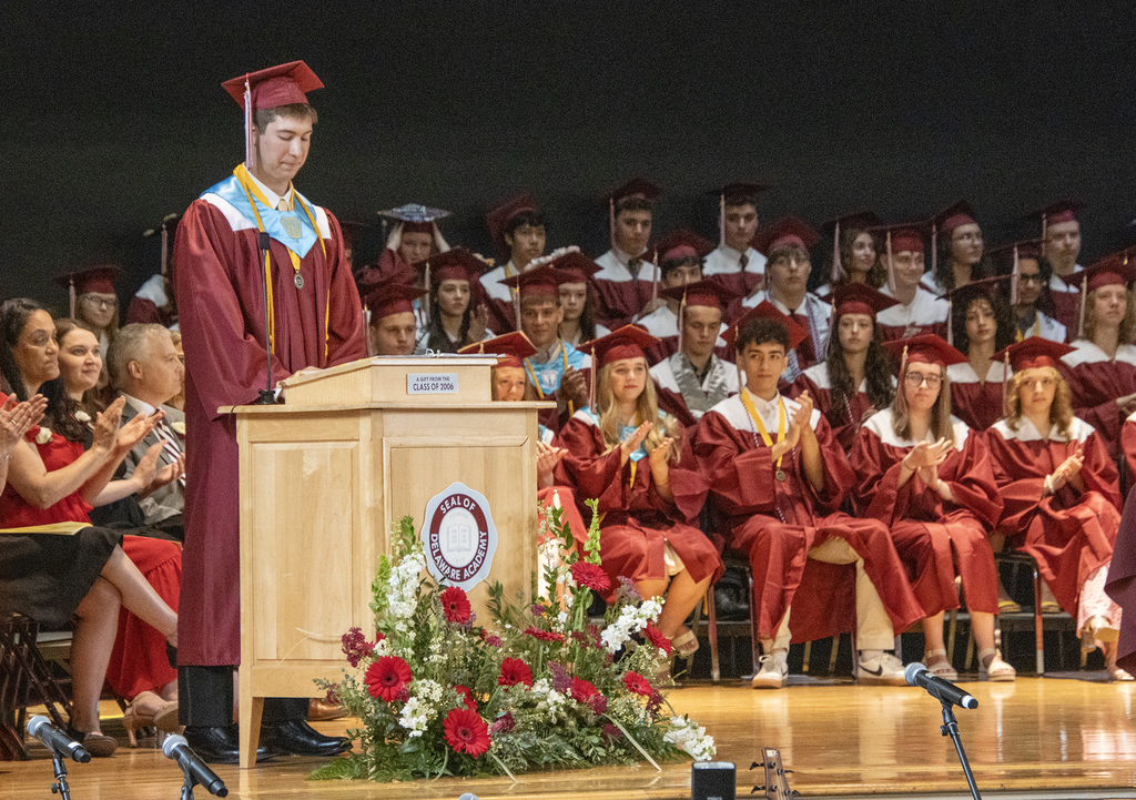 valedictorian looks down as audience applauds