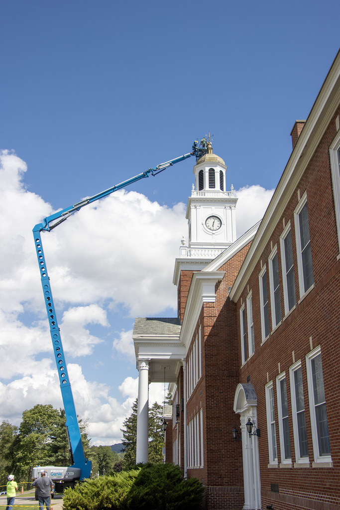 workers in a lift work on cupola