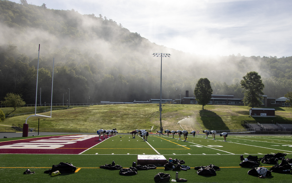misty mountain overlooks football practice
