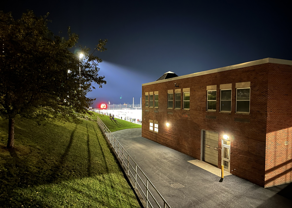 view of field at night from behind school building