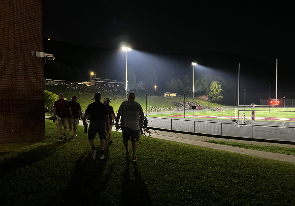 coaches approach the field at night