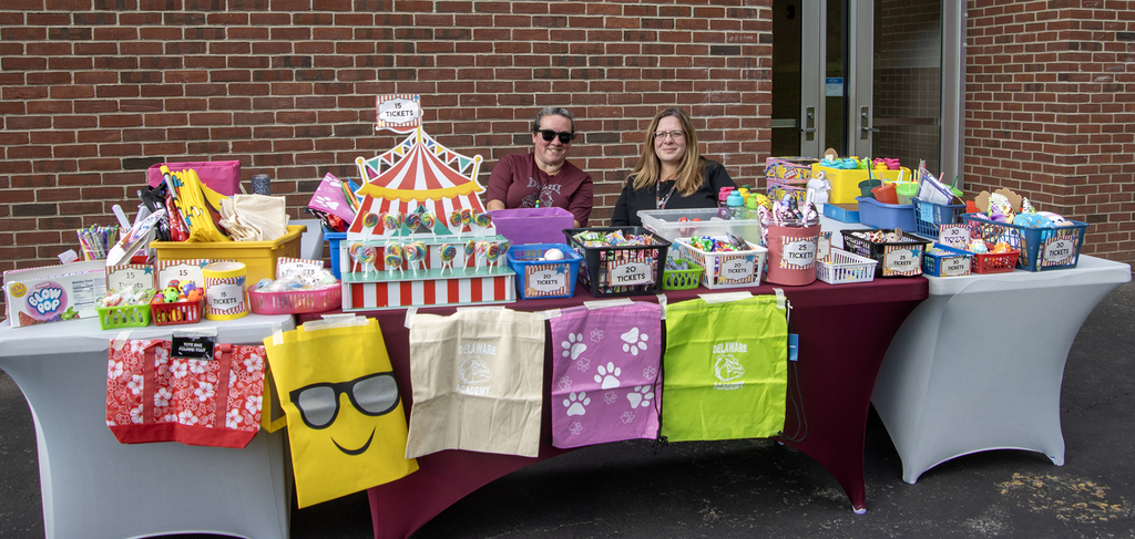 2 adults staff the prize table