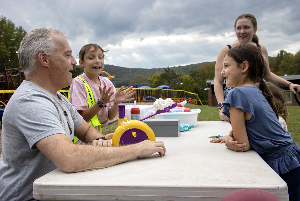 students laugh and applaud as Mr. Shultz prepares for whip cream in the face