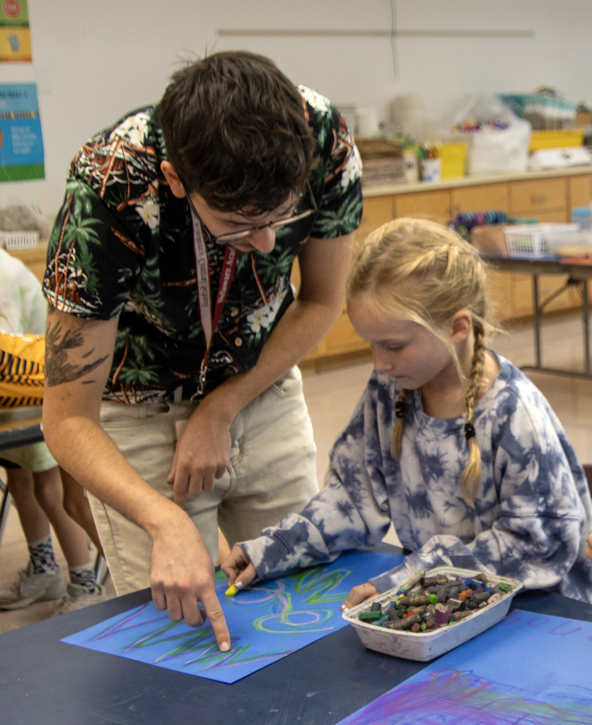 Mr. Kollig helps a student draw the northern lights