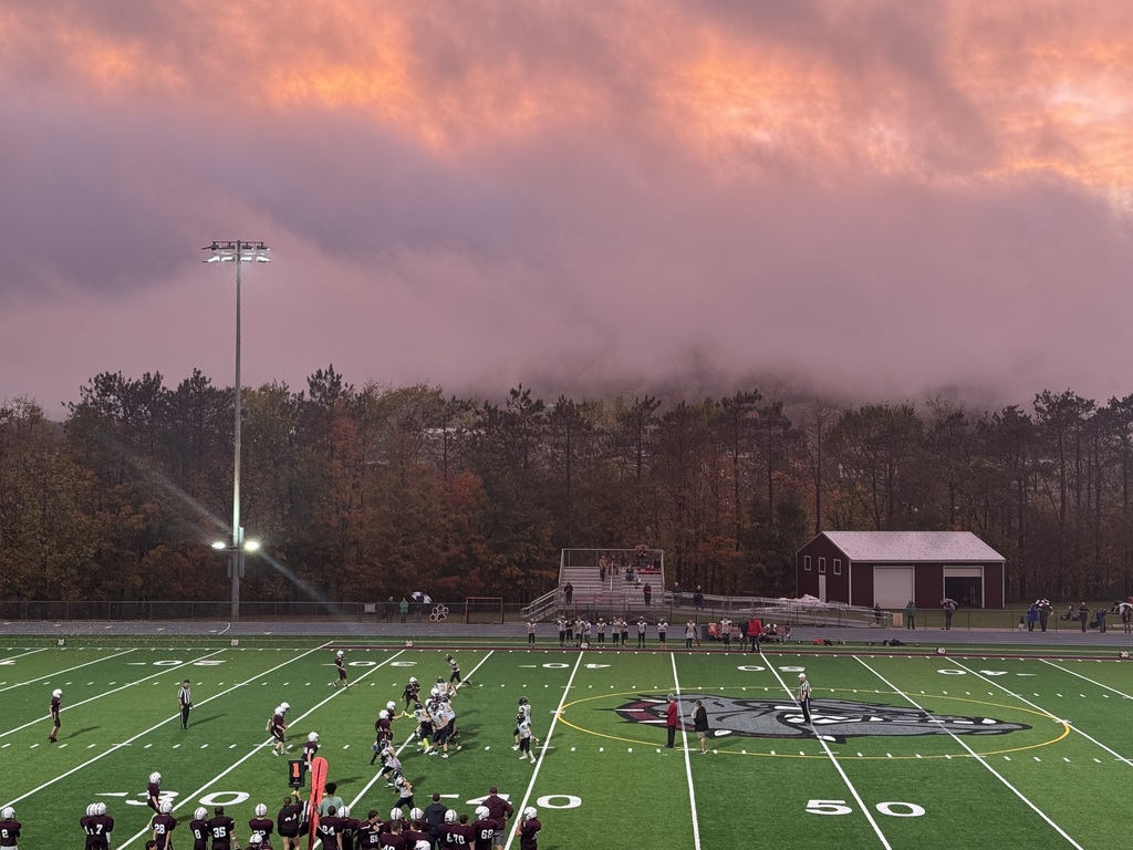 football players on field with dramatic sky