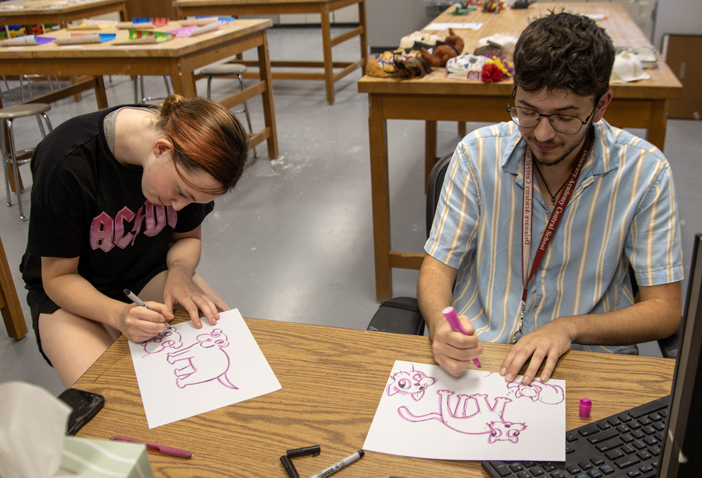 student and art teacher draw cartoons