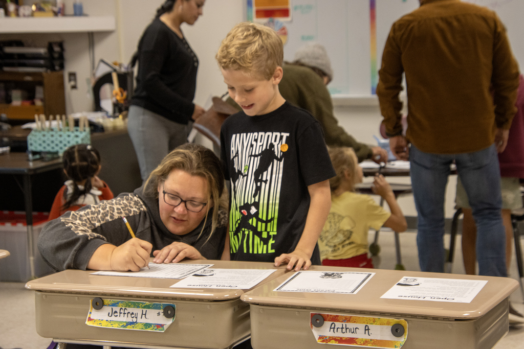 mother signing sheet with student watching