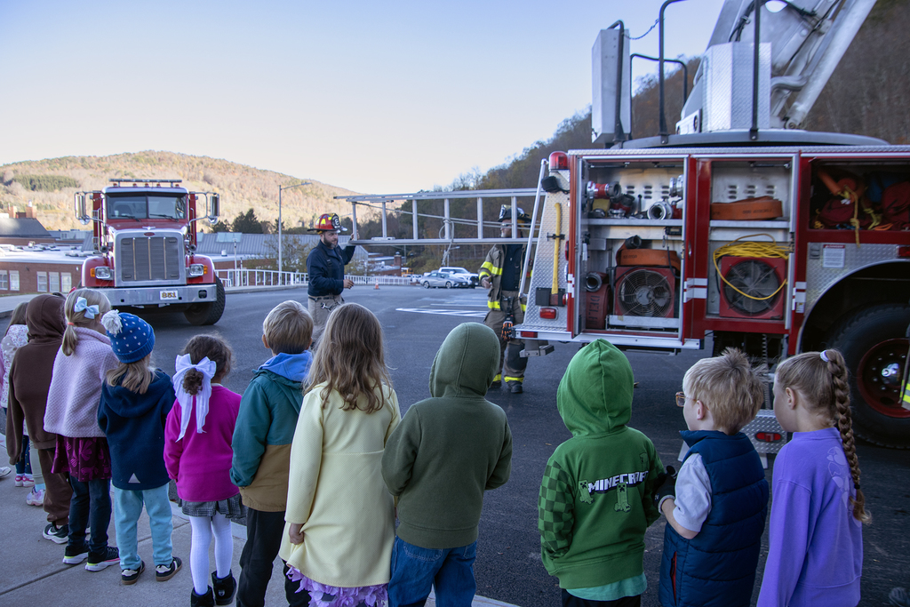 firefighter shows ladder to students