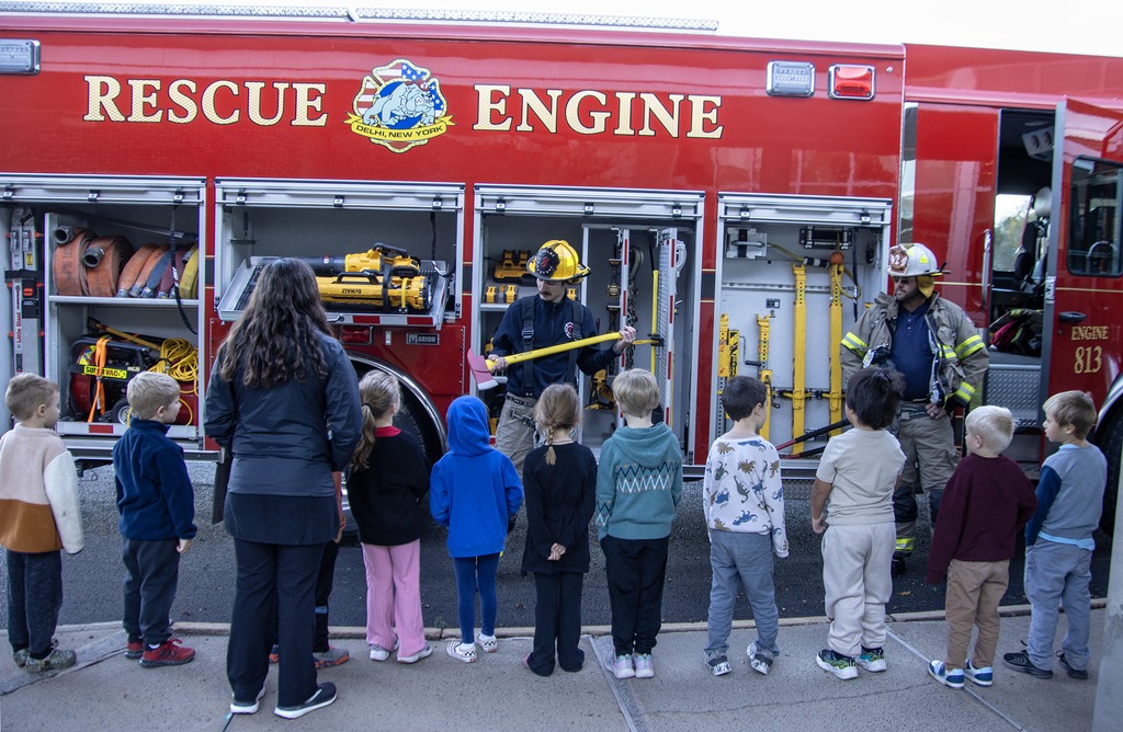firefighter shows axe to students and teacher