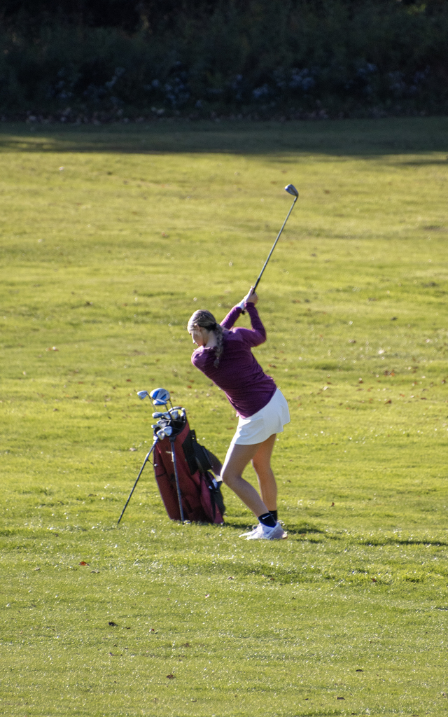 golfer swings on the fairway