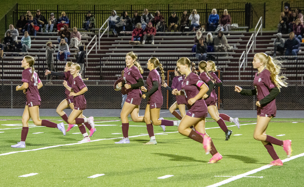 girls soccer team running on field
