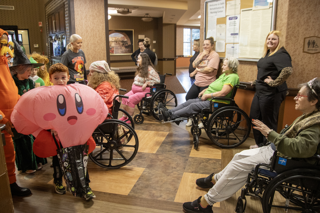 2nd grade students in costume visit with residents of nursing home