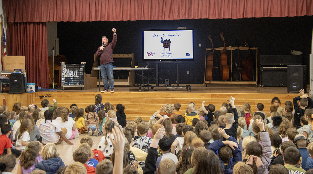 elementary assembly, students on floor, Mr.Albright on stage