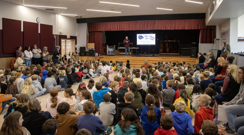 elementary assembly, students on floor, Mr.Albright on stage