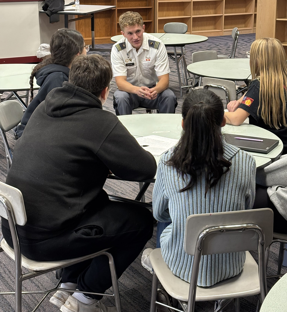 Cadet Gregory speaks with 4 students at a small table
