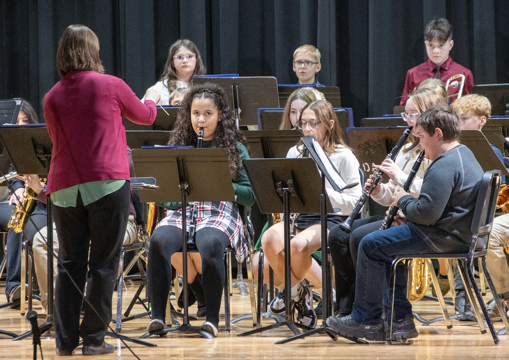 conductor directing middle school band on stage