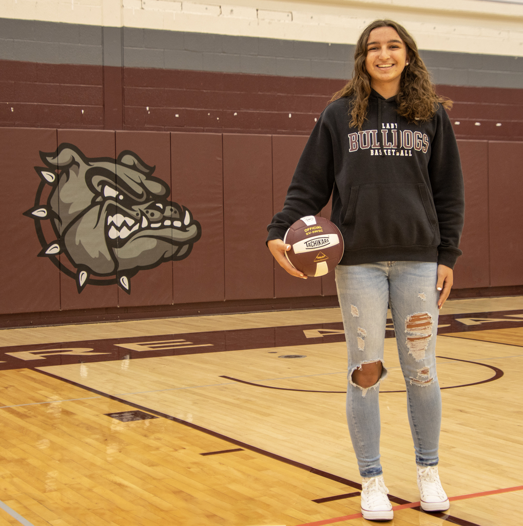 rebecca verspoor poses in gym holding a volleyball