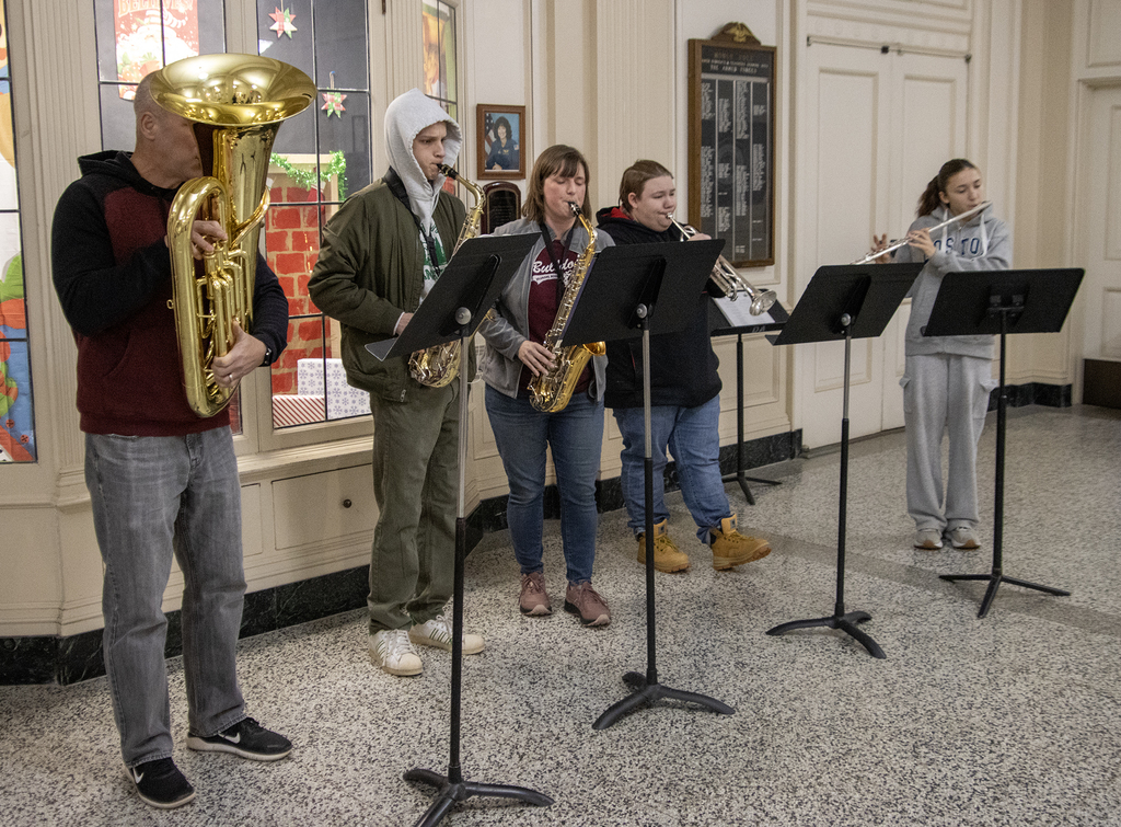 wind ensemble plays Christmas carols in lobby for arriving students