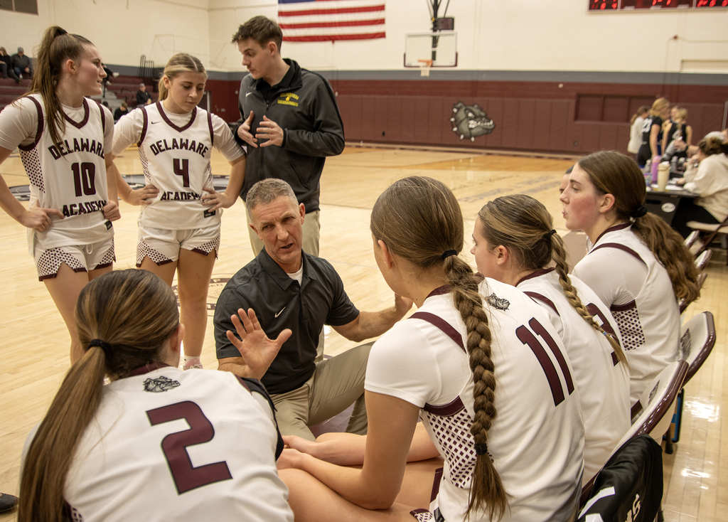 coaches speaking to players on the bench