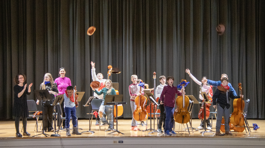 the orchestra throws their hats in the air