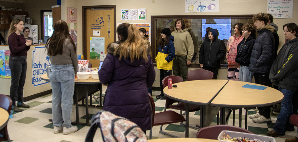 teacher speaks to students and teacher in early childhood education classroom