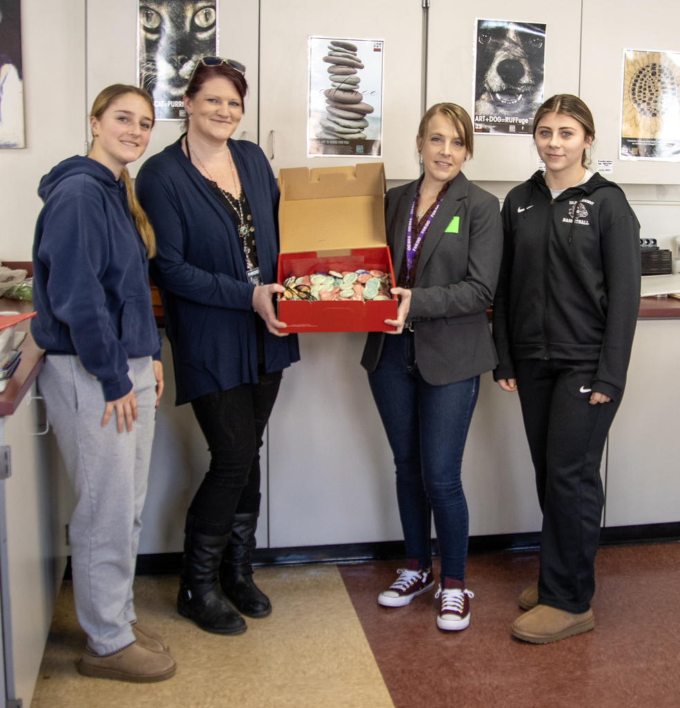 2 students present ceramic recovery buttons to 2 FORDO presenters
