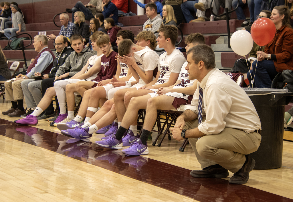 boys basketball team and coach on the bench and courtside