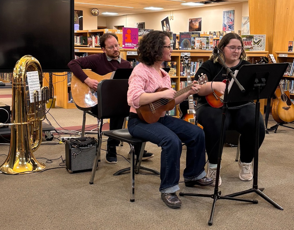 a student plays ukelele accompanied by Mr. & Mrs. Gibson