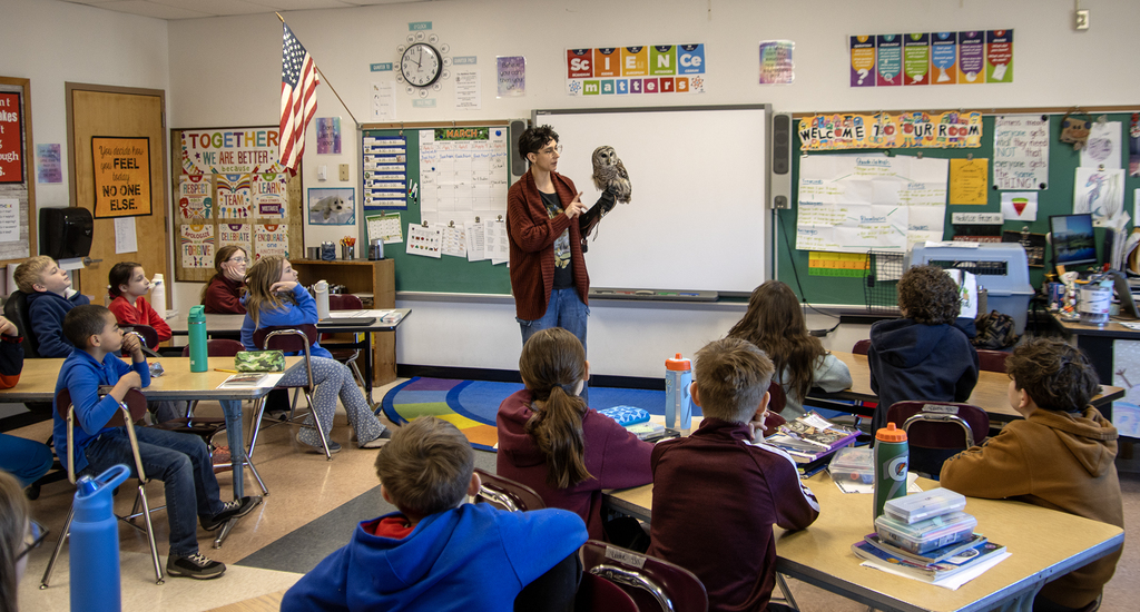 Mellow the owl and Genevieve Salerno visiting a classroom