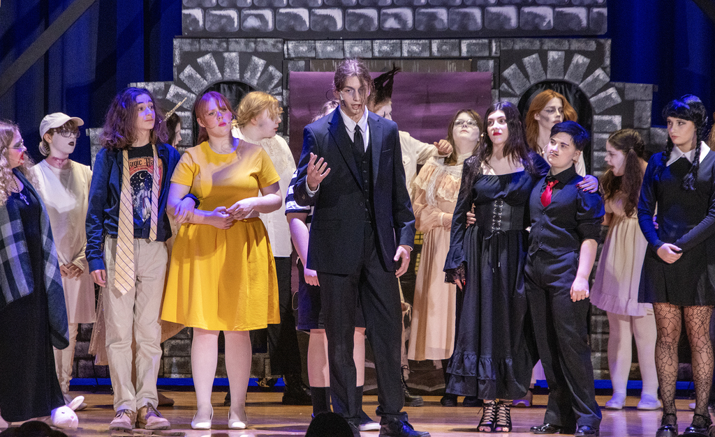 Lurch sings on stage, surrounded by other cast members