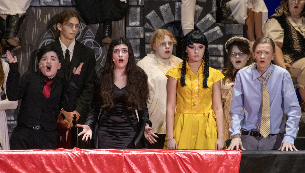 7 cast members ion a row on stage