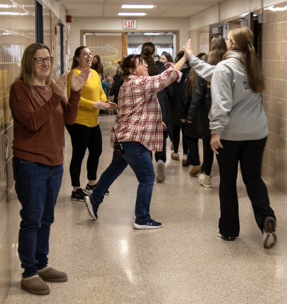staff applaud and high-five a coach