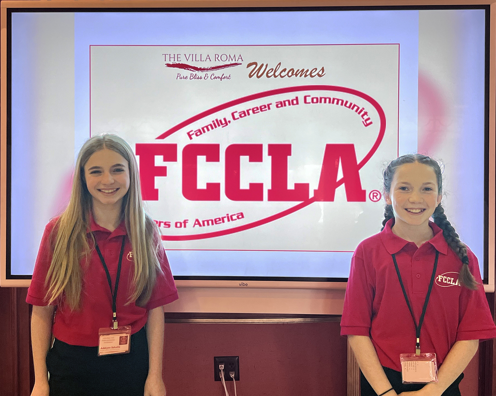 2 FCCLA members pose in front of FCCLA sign