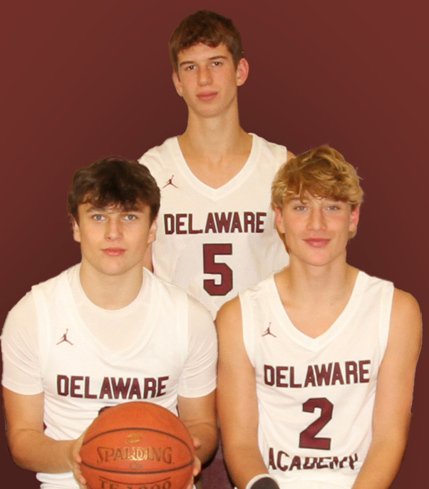 3 boys basketball players, one holding a basketball