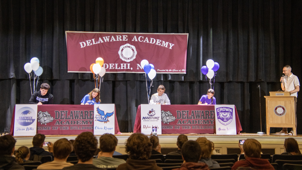 Nate :Lull at lectern as 4 students sign their papers