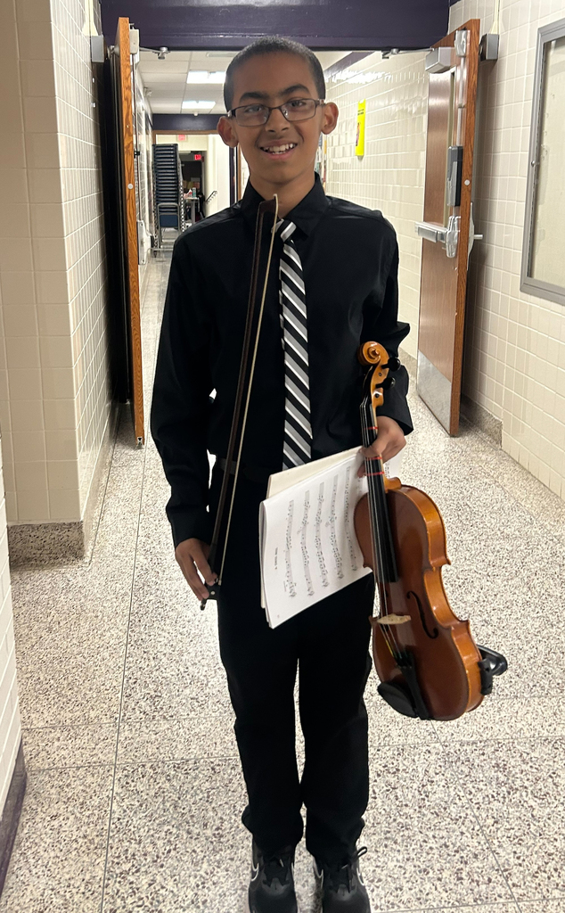 boy wearing dress shirt and tie holding a violin and music