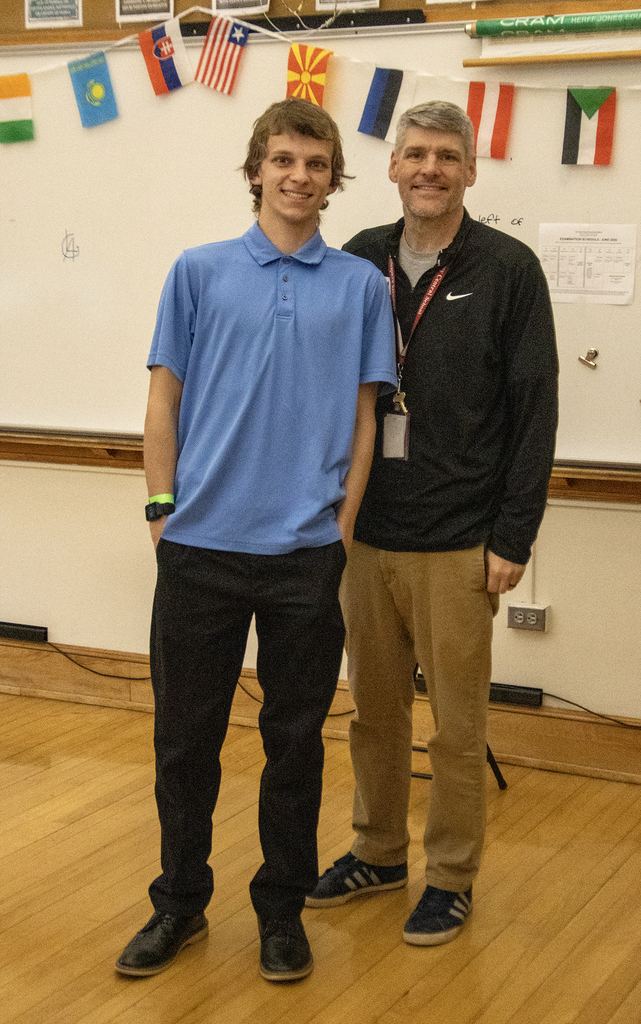 student poses with history teacher