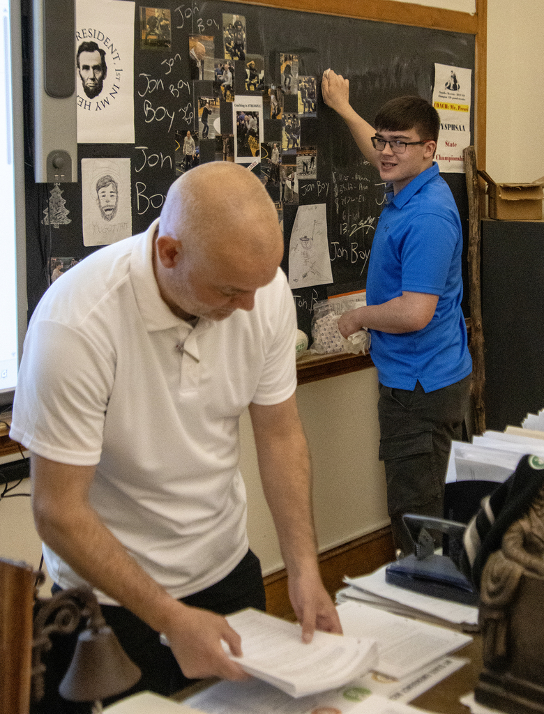 student cleaning the blackboard in Mr. Pecori's room