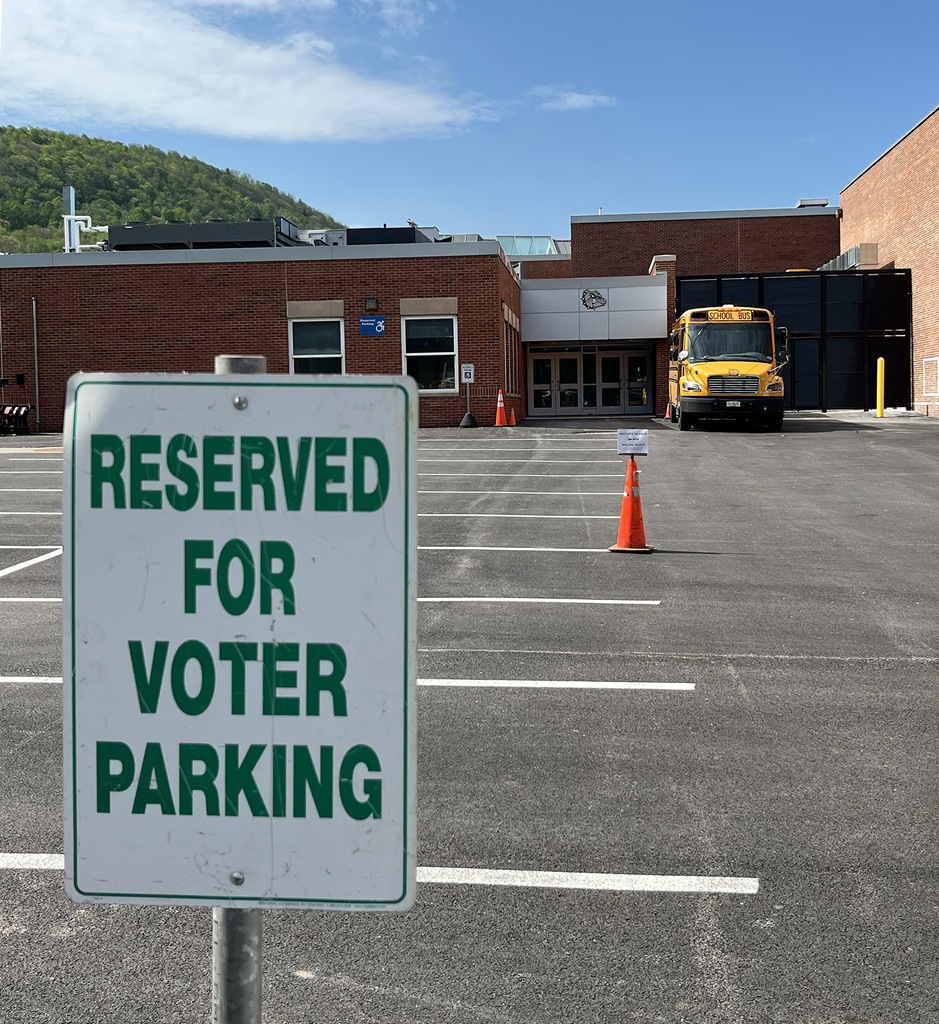 view of middle school gym entrance, with "Reseerved for Voter Parking" sign in foreground