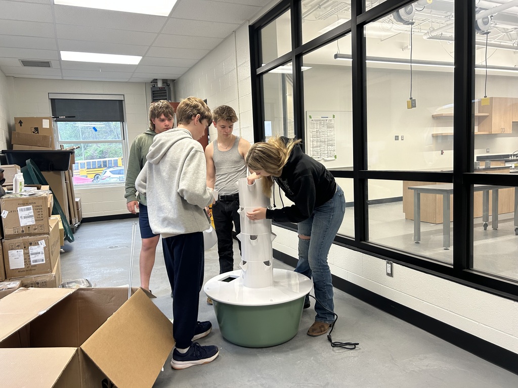 3 students assembling hydroponic growing equipment