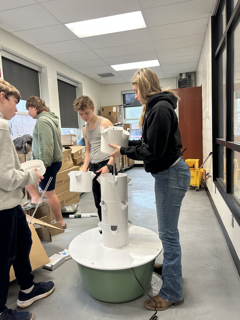 3 students assembling hydroponic growing equipment