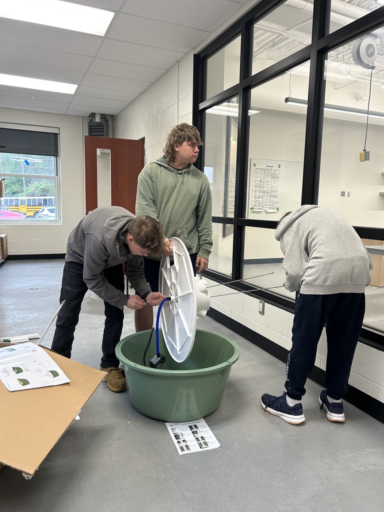 3 students assembling hydroponic growing equipment