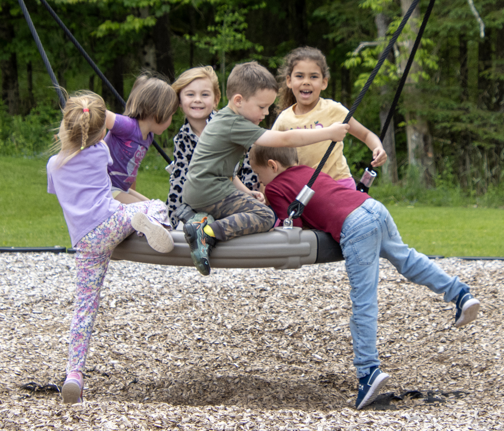 6 children on a tire swing