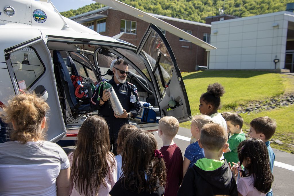 students listen to a flight paramedic as they stand around a helicopter